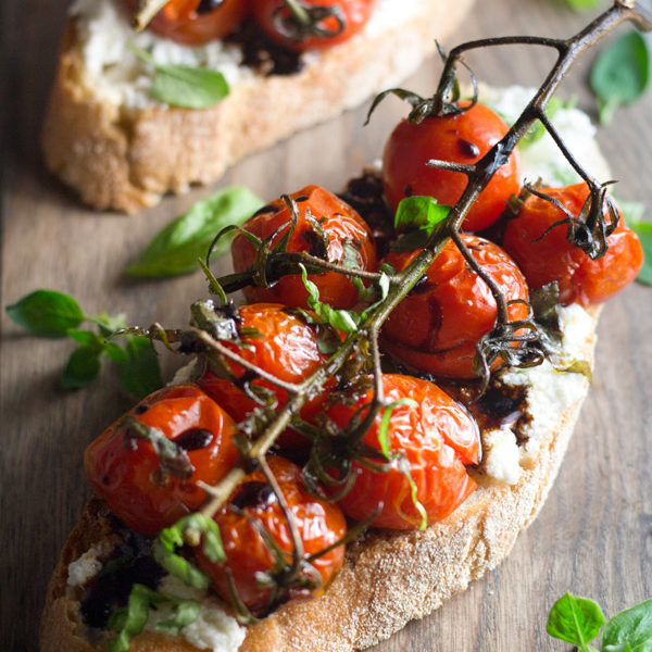 Vined Roasted Tomatoes are roasted slowly with garlic, avocado oil, and basil. Served on top of toast, roasted garlic basil ricotta spread, and drizzled with balsamic glazed, it is too die for. | www.butterandthings.com